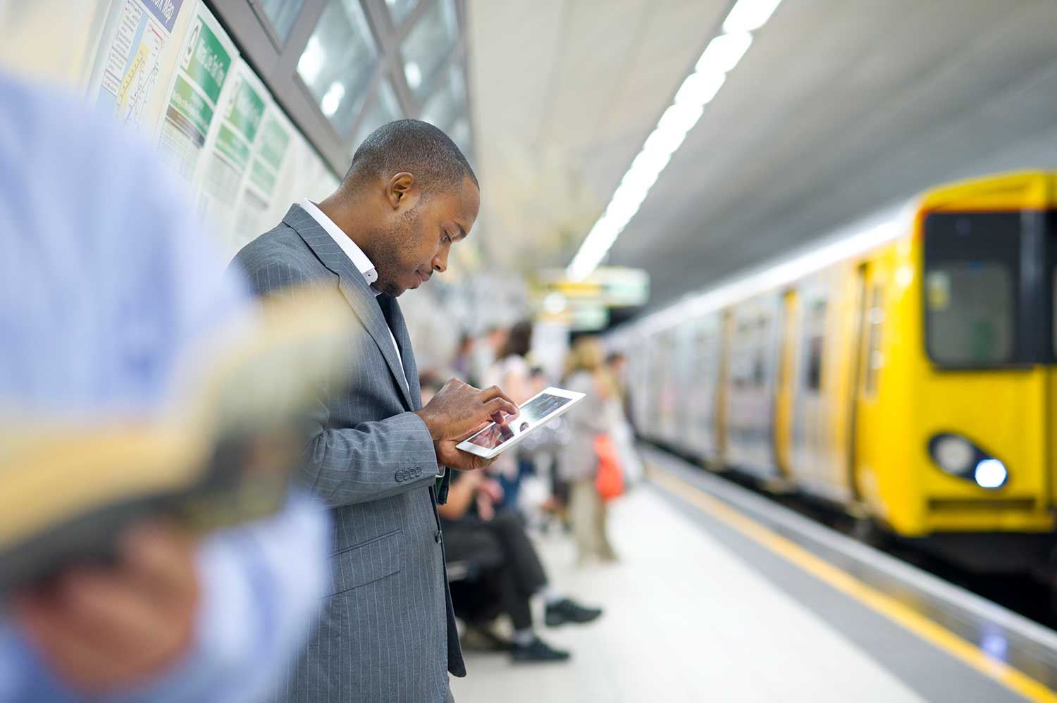 guy-on-ipad-waiting-for-train---blog-image-2018.jpg